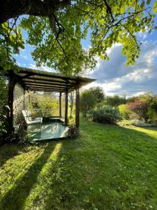 un gazebo in un cortile con prato verde di Pensiunea La Plai - Oază de Relaxare a Plaiu Şarului