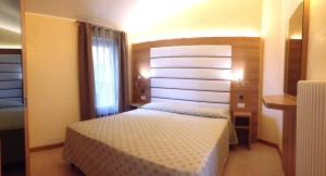 a hotel room with a bed and a window at Residence Primavera in Bardolino