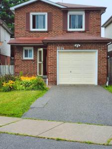 a brick house with a white garage at Your home away from home in Pickering