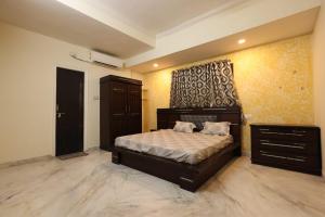 a bedroom with a bed and a dresser in it at EZ-stay Villa in Hyderabad