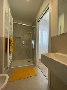 a bathroom with a glass shower and a sink at A due passi dal mare - Family Apartment in Lido di Jesolo