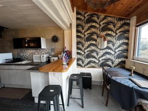 a kitchen with a counter and a table with stools at La Cigale Ardéchoise, Cozy - View - Quiet in Chalencon