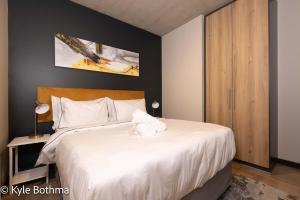 a bedroom with a large bed with white sheets at Smart Apartment Luxury in Midrand +37 photos