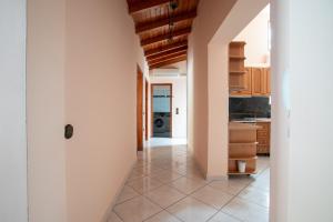 a kitchen with white walls and a tile floor at Fhouse Luxury Apartment in Igoumenitsa