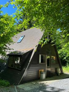 a brown house with a gambrel roof with a window at Forest Lodge Durbuy in Durbuy