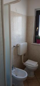 Un baño con un inodoro blanco y un lavabo. en B&B La Foglietta, en Paganica