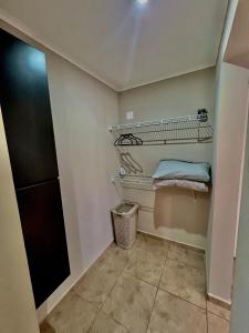 a laundry room with two shelves and a trash can at The Gold Vacation Villa in Santa Cruz