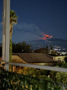 a mountain in the distance with a fire in the sky at Casa Vacanze - La Barchetta in Giardini Naxos