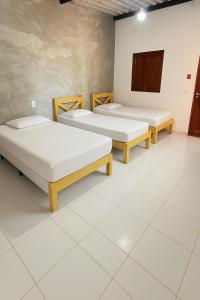 three beds in a room with white tile floors at Recanto Do Piu in Padre Bernardo +27 photos