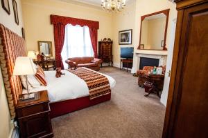 1 dormitorio con 1 cama grande y chimenea en Clarence Court Hotel en Cheltenham