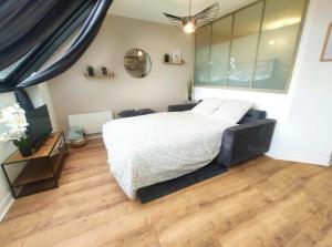 a bedroom with a white bed and a wooden floor at DisneyLand - Paris 20 min - Parking - 6 personnes in Chelles