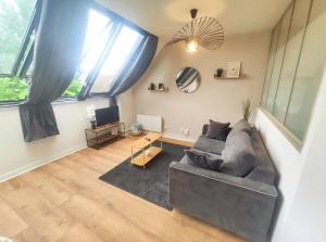 a living room with a couch and a tv at DisneyLand - Paris 20 min - Parking - 6 personnes in Chelles