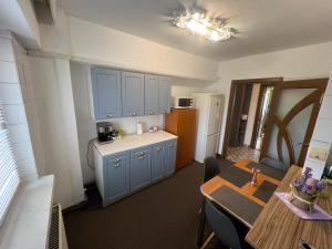 a small kitchen with blue cabinets and a table at Downtown Apartment in Craiova