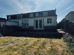 a house sitting on top of a yard at Modern Comfort 4BR Home for 10 in North Weald