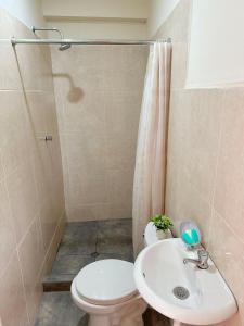 Un baño con inodoro, lavabo y ducha. en Hospedaje Maranura Quillabamba, en Maranura 2 fotos más