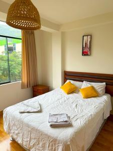 Un dormitorio con una cama con dos toallas encima. en Hospedaje Maranura Quillabamba, en Maranura