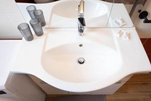 a white sink in a bathroom with two cups at Maison Turin Airport in Caselle Torinese +9 photos