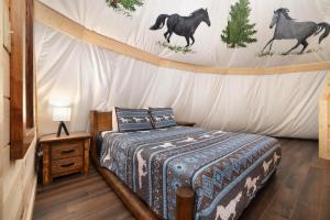 セバービルにあるFlyin' Horse Teepee, Free Tickets, NO catch!の壁に馬が描かれたテントの中にベッドがある寝室