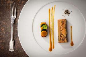 un piatto bianco con del cibo su un tavolo di Hôtel Beau Rivage Condrieu a Condrieu