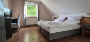 a bedroom with a bed and a desk and a window at Up de Sülten in Bergen