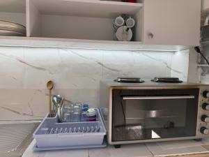 a kitchen with a microwave with a tray next to it at Villa Gjoka in Velipojë +20 photos