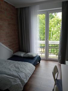 En eller flere senge i et værelse på Apartament Centrum Podjasnogórski