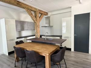 a kitchen with a wooden table and chairs at Golf course around the corner! in Nieuwveen