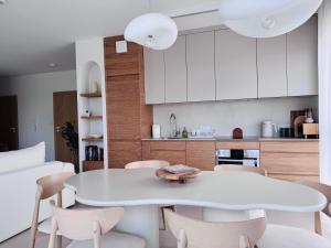 a white kitchen with a white table and chairs at Puro in Złotów