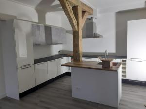 a kitchen with white cabinets and a wooden counter top at Golf course around the corner! in Nieuwveen