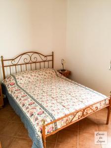 a bed in a bedroom with a bedspread on it at Casas Da Lagoa - T2 Sul in Aldeia de Brescos