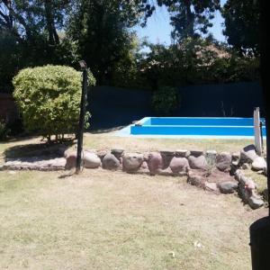 a rock retaining wall with a pool in a yard at La casita in Mendoza