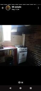 a kitchen with a stove and a brick wall at La casita in Mendoza