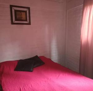 a red bed with a black pillow on top of it at La casita in Mendoza