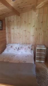a bedroom with a bed in a wooden cabin at Domek nad jeziorem Gowidlińskim in Podiazy