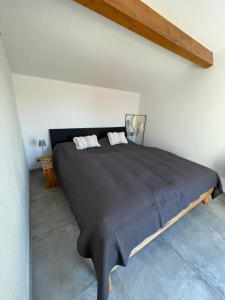 a bedroom with a large black bed in a room at Maison Lagune bleue Gruissan in Gruissan