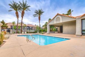a swimming pool with palm trees in front of a house at 5 Mi to Las Vegas Strip Condo with Community Perks! in Las Vegas