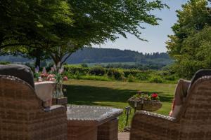 a patio with two chairs and a table with flowers at Grand Georgian Villa Sleeps up to18 Guests Dogs Welcome in Linton