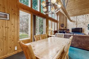 a dining room with a wooden table and some windows at Eagle Crest: Prairie Falcon Retreat in Redmond