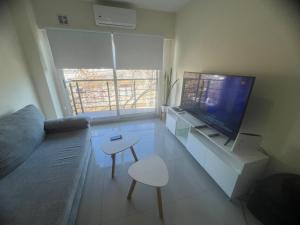 a living room with a couch and a flat screen tv at Calmo y luminoso cercano a avenida Avellaneda in Buenos Aires +3 photos