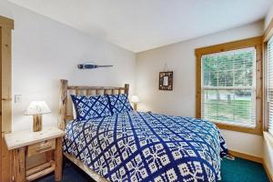 a bedroom with a blue and white bed and a window at Eagle Crest: Prairie Falcon Retreat in Redmond +26 photos