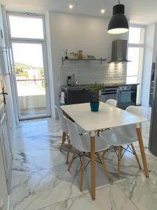 a kitchen with a table and chairs in a kitchen at Casa Sanna, T2 waterfront Miomo, Cap Corse in Santa-Maria-di-Lota +5 photos