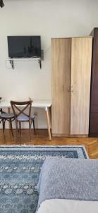 a living room with a tv and a table and a couch at Studio apartman in Meljine