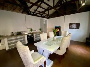 a kitchen with a white table and white chairs at Arcade Art Loft in Johannesburg +34 photos