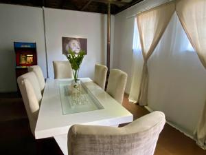 a white table with chairs and a vase with flowers on it at Arcade Art Loft in Johannesburg