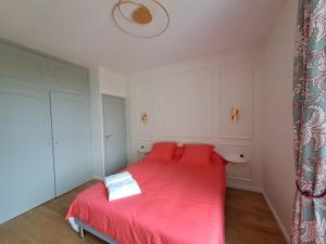 ein Schlafzimmer mit einem roten Bett mit roten Kissen in der Unterkunft Le Relais du Golf- Château de la Touche in Ballan-Miré