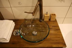 a glass bowl sink with a faucet in a bathroom at Dīķsalas in Gulbene