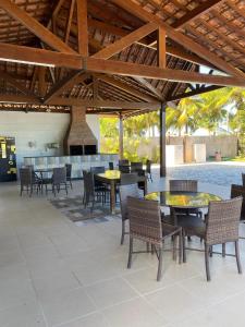un patio al aire libre con mesas y sillas y un bar en Espaço inteiro Casa de Praia no Brasil Pernambuco, en Paulista