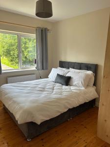 Un dormitorio con una cama grande con almohadas blancas. en Fab location for exploring Clare, en Ennis