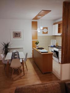 a kitchen with a table and a dining room at Apartment Bella Vista in Kravlja +4 photos