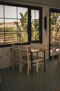 a dining room with a table and chairs and windows at La Vida otel in Urla